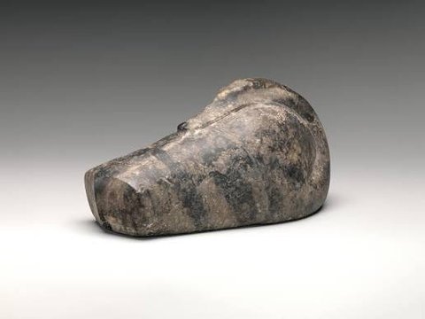 A dark, mottled stone weight shaped like a resting duck.