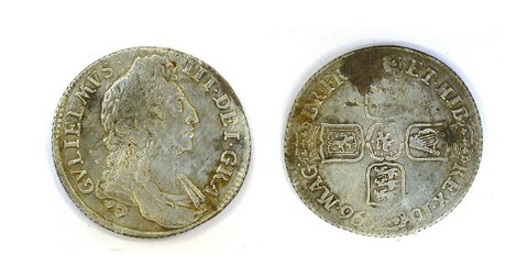 Both faces of a worn silver shilling, with a king's portrait on one side and four shields in a cross on the other.